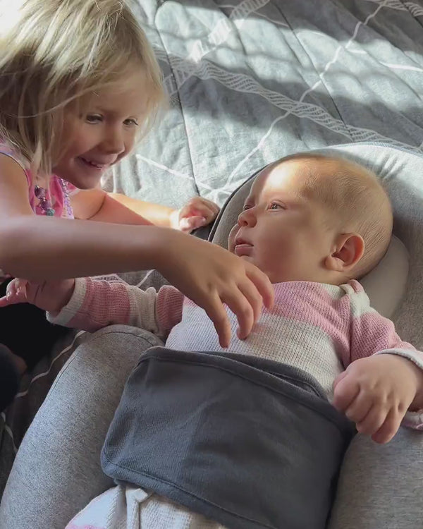 Kind kuschelt mit Baby im Babynest