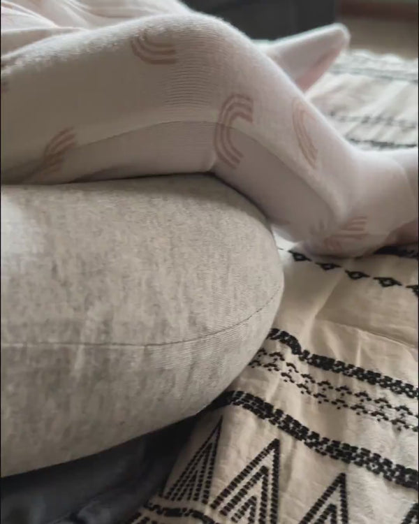 Baby liegt entspannt mit angehobenen Beinen