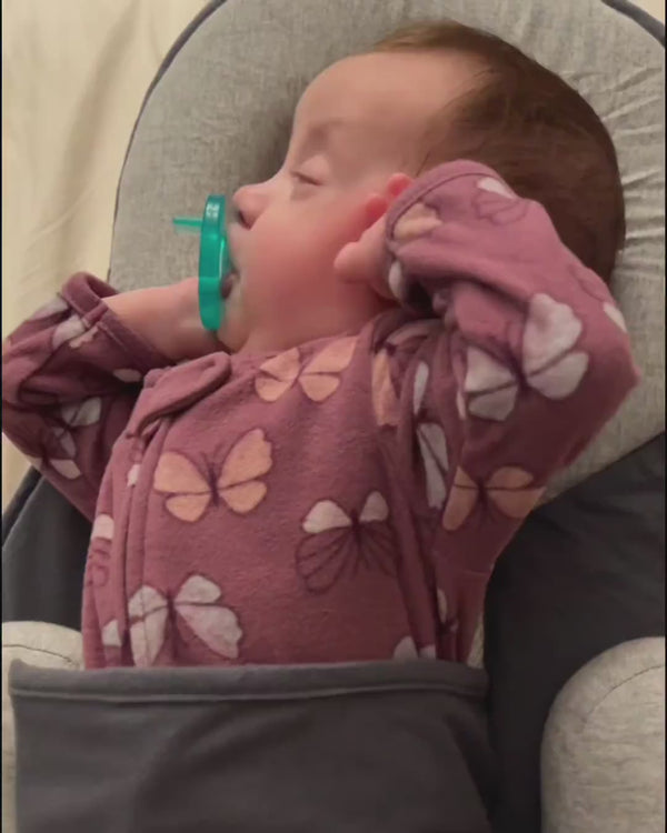 Baby schlummert mit Schnuller im Babynest